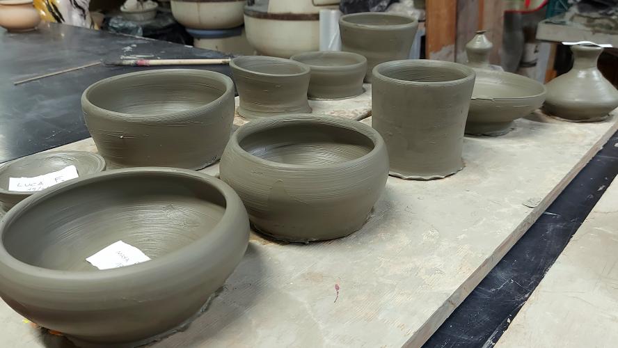 Lezione di tornio per pa creazione di vasi in argilla. Corso di ceramica a Bologna